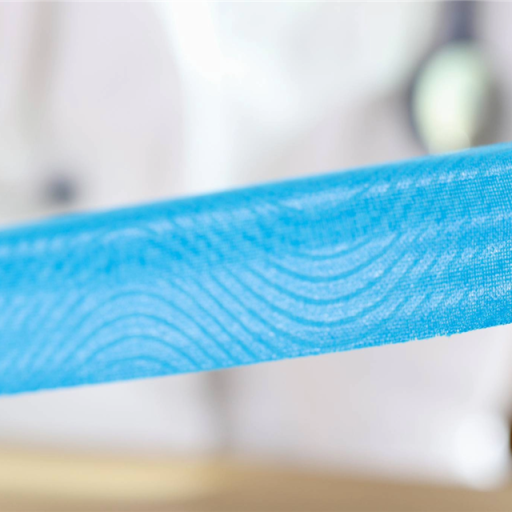 Ergotherapeutin legt Kinesio-Tape am Handgelenk und an den Fingern einer Patientin in der Handrehabilitation an